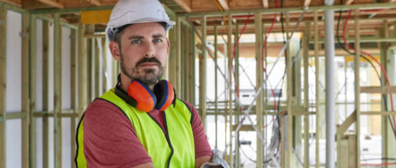 Man wearing safety gear inside a construction site.